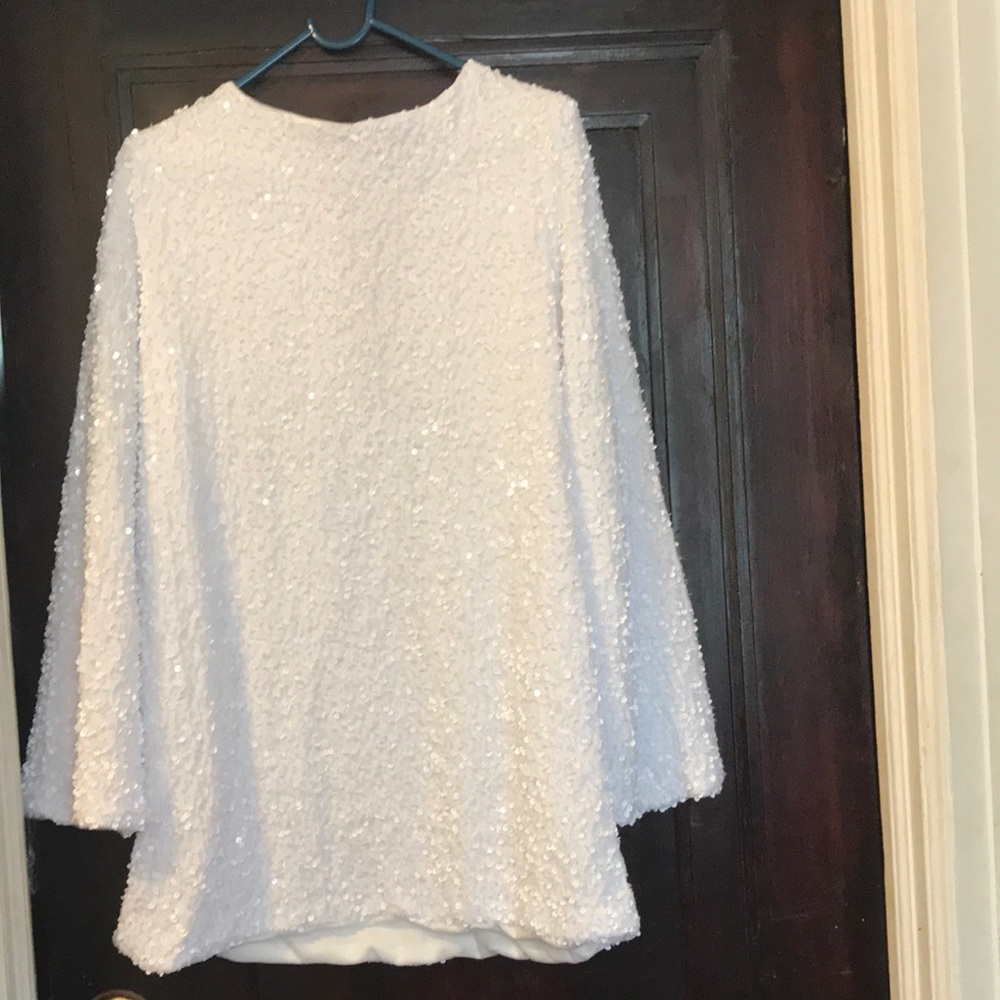 37.   Brand new, white sequined dress with tied black bow.